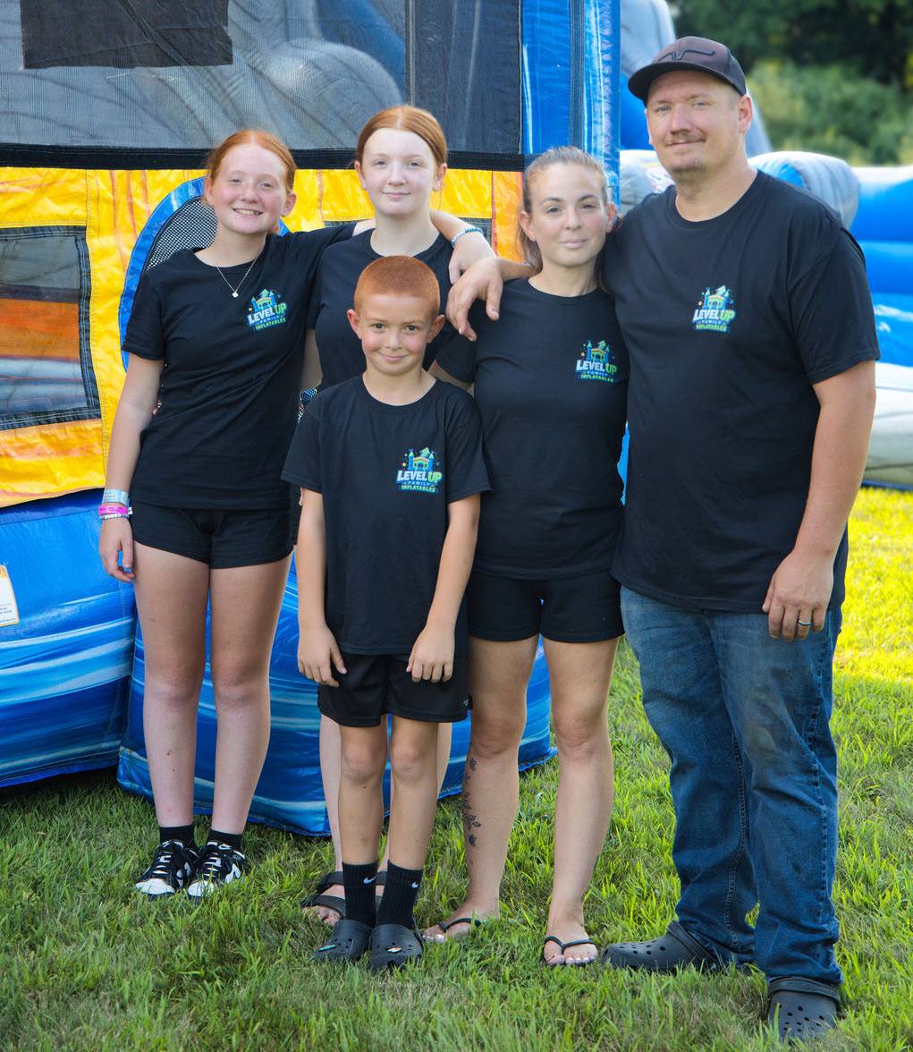 Our family team standing together in front of a Level Up inflatable